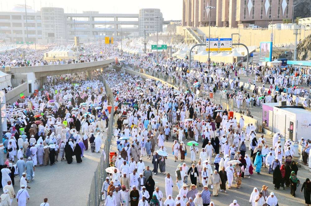 Mecca, Saudi Arabia - October 16, 2013: A group of Hajj pilgrims walk in the city of Mina to perform the ritual of stoning the devils at Jamarat. Around 2 million people perform the Hajj every year.